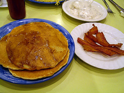 tall stack of pancakes with crispy bacon