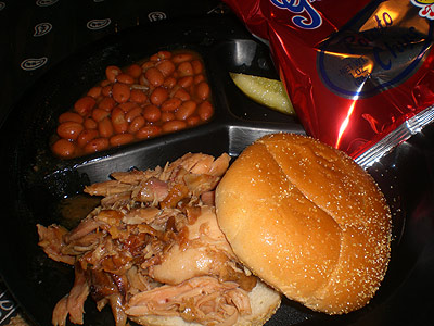 Pulled chicken sandwich, pinto beans and potato chips from Pit To Plate BBQ
